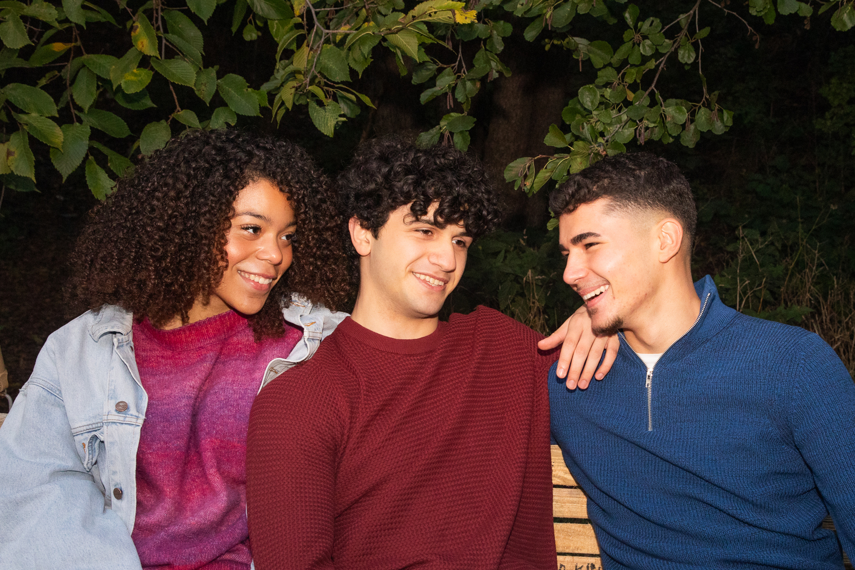 Tre personer umgås på en bänk